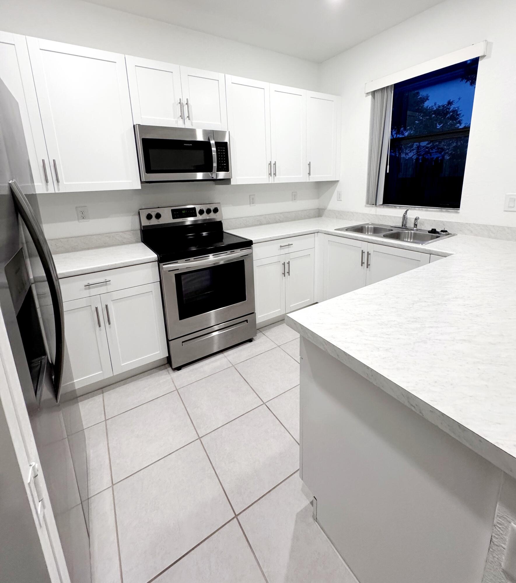 28706 Southwest 133rd Court Homestead, FL 33033 - Photo 3 of 40 a kitchen with stainless steel appliances a stove a sink and a microwave
