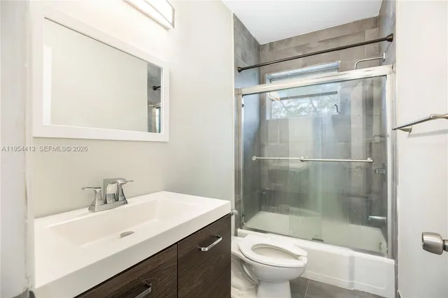 a bathroom with a shower a sink a toilet and mirror