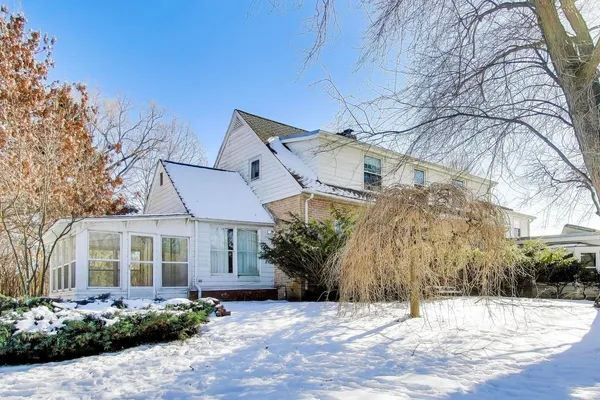 a front view of a house with a yard and tree s