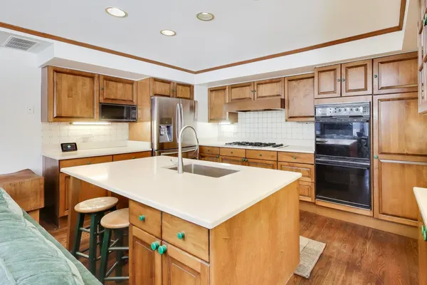 a kitchen with kitchen island a stove and a sink