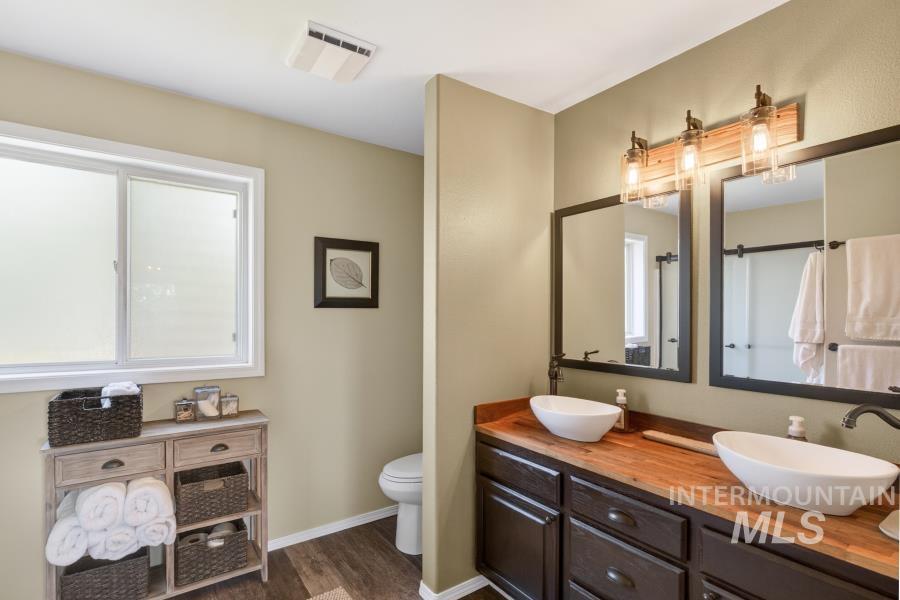 1673 Appaloosa Road Moscow, ID 83843 - Photo 33 of 50 Double vanity featuring wood-finish countertops, vessel sinks, and dark cabinetry