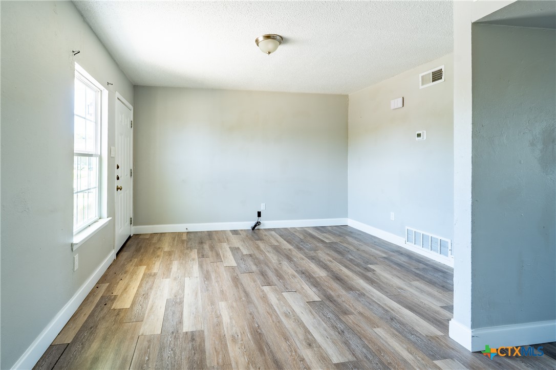 512 Sunset Lane, Unit AD Copperas Cove, TX 76522 - Photo 7 of 23 an empty room with wooden floor and windows