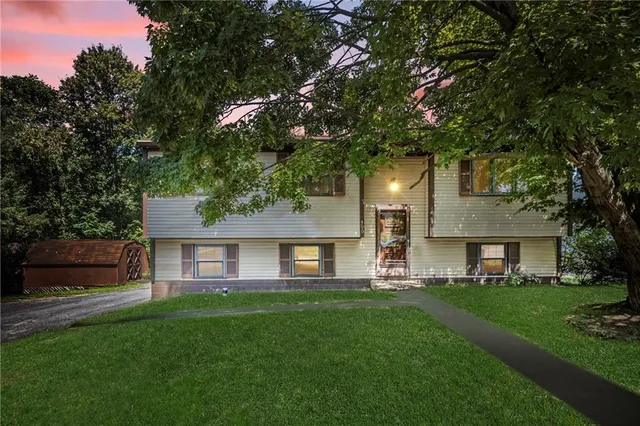 a front view of a house with a garden and yard