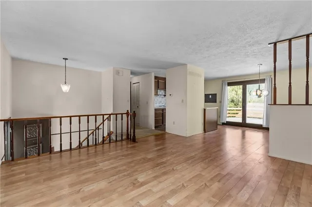 a view of a hallway with wooden floor and windows