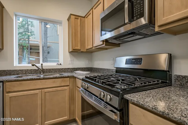 a kitchen with stainless steel appliances granite countertop a stove and a microwave