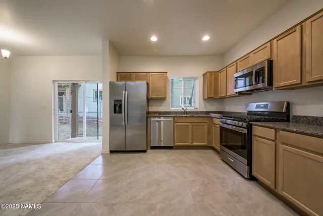 a kitchen with stainless steel appliances granite countertop a refrigerator sink and cabinets