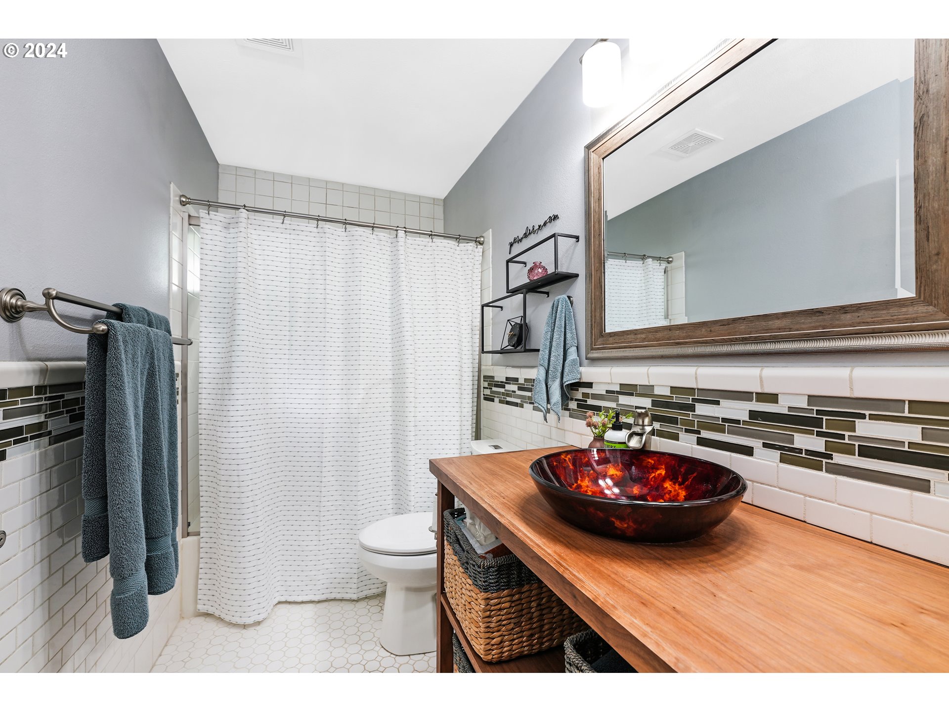 7702 Southwest Barnes Road, Unit D Portland, OR 97225 - Photo 11 of 24 a bathroom with a sink a toilet and shower curtain