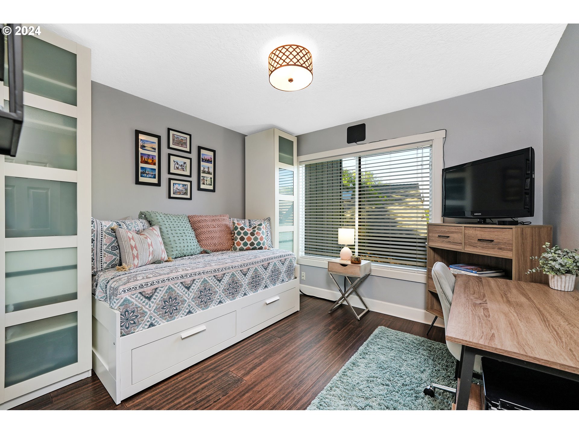 7702 Southwest Barnes Road, Unit D Portland, OR 97225 - Photo 12 of 24 a living room with furniture and a flat screen tv