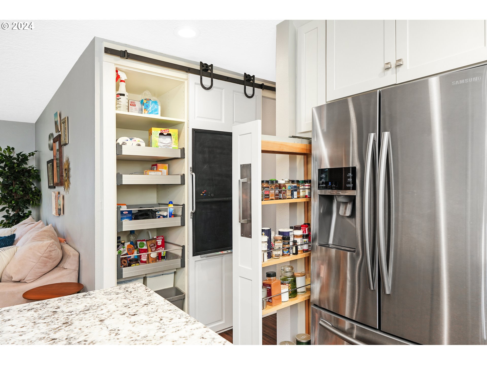 7702 Southwest Barnes Road, Unit D Portland, OR 97225 - Photo 7 of 24 a kitchen with stainless steel appliances kitchen island granite countertop a refrigerator and a sink