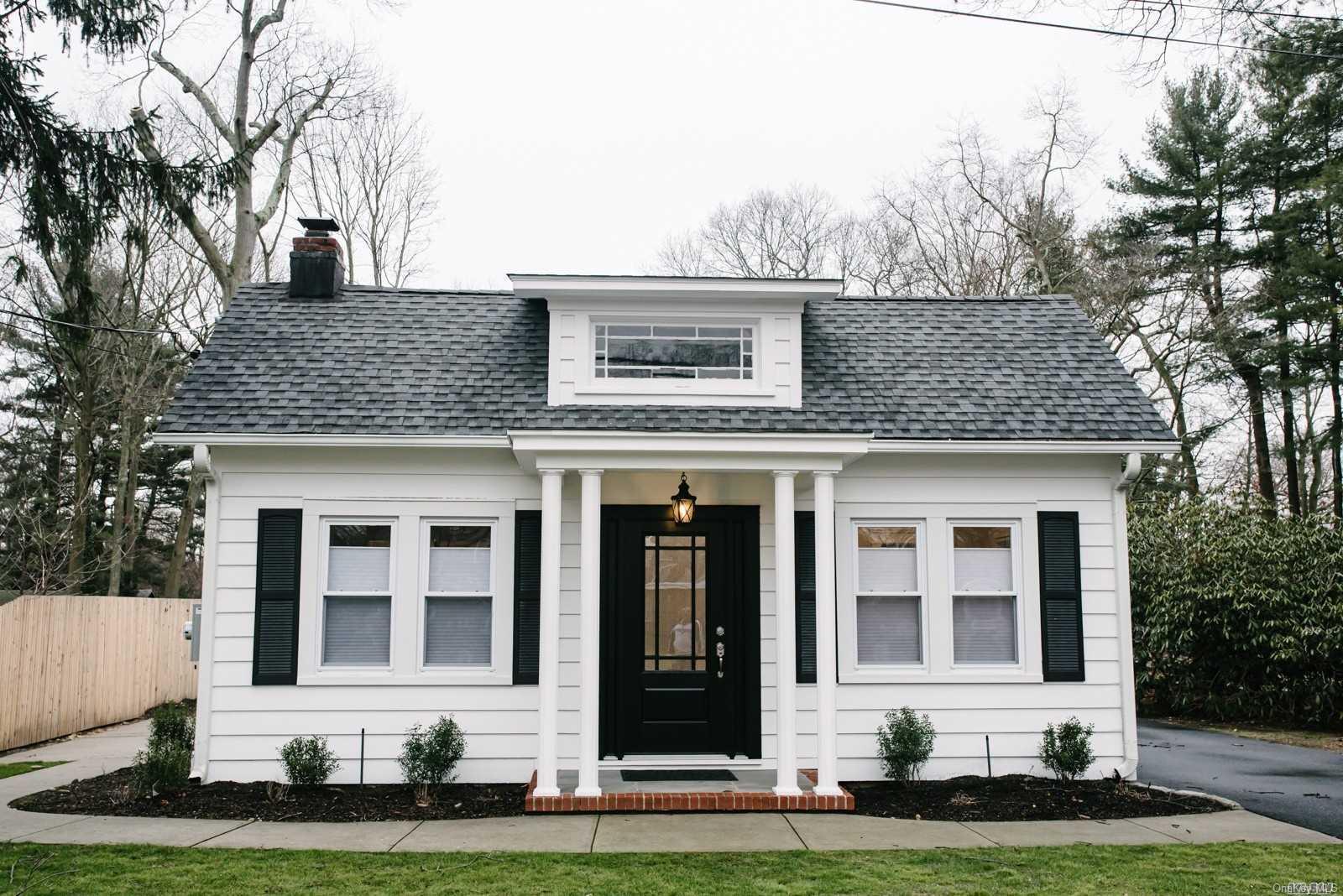 front view of a brick house with a yard