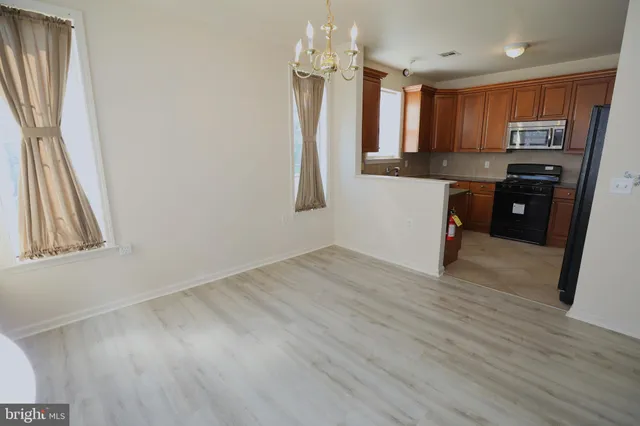 a kitchen with granite countertop a refrigerator stove and sink
