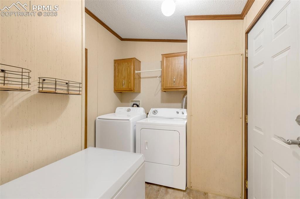 13335 Gymkhana Road Peyton, CO 80831 - Photo 23 of 38 Dedicated utility room featuring wall-mounted cabinetry, a built-in shelf with wire baskets, and light-toned wall paneling