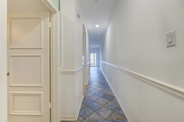 a view of a hallway with wooden floor and furniture