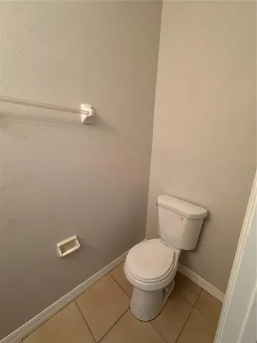 a white toilet sitting next to a white sink and vanity