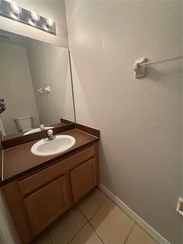 an empty room with windows and chandelier fan