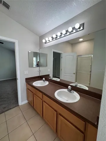 a bathroom with a glass shower door and sink
