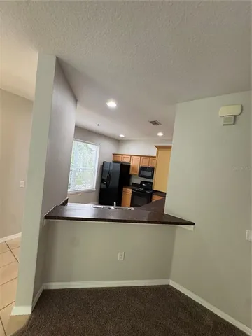 a view of kitchen with stainless steel appliances granite countertop white cabinets and a granite counter top