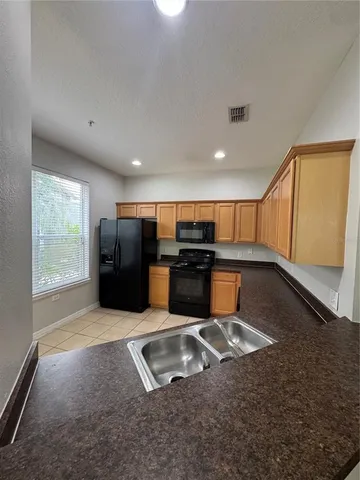 a kitchen with stainless steel appliances granite countertop a sink and a stove