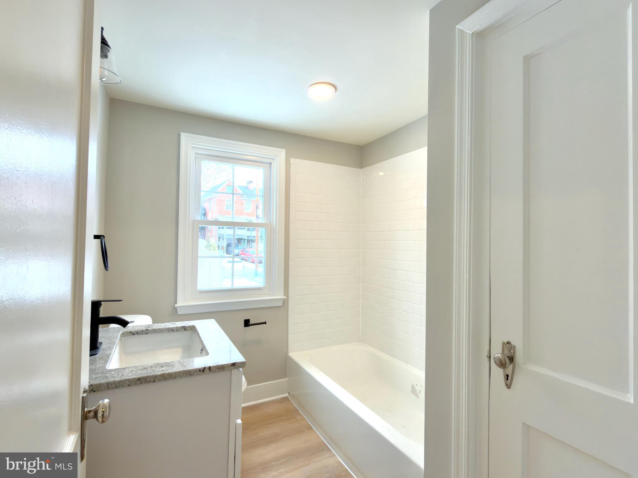 244 Sycamore Road Reading, PA 19611 - Photo 18 of 27 a bathroom with a granite countertop sink mirror bathtub and shower