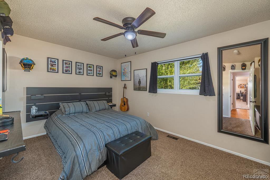 49 Calhoun Road Pueblo, CO 81001 - Photo 15 of 24 a bedroom with a large bed and a chandelier