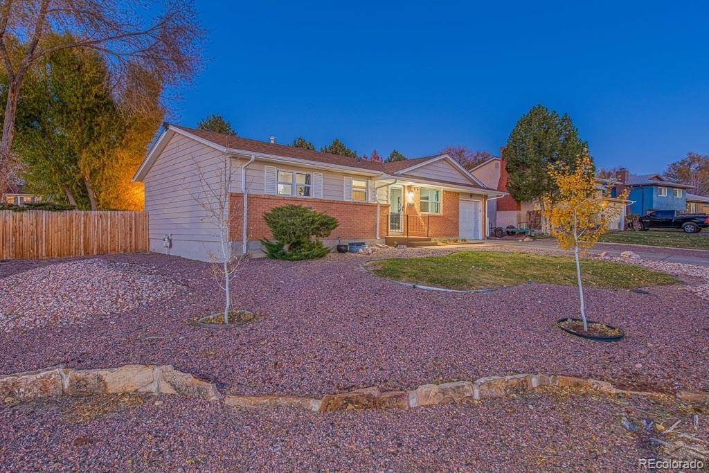 49 Calhoun Road Pueblo, CO 81001 - Photo 3 of 24 a front view of a house with a yard and a garage