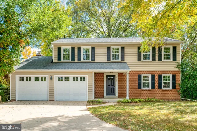 a view of a white house with a large windows and a big yard and large trees