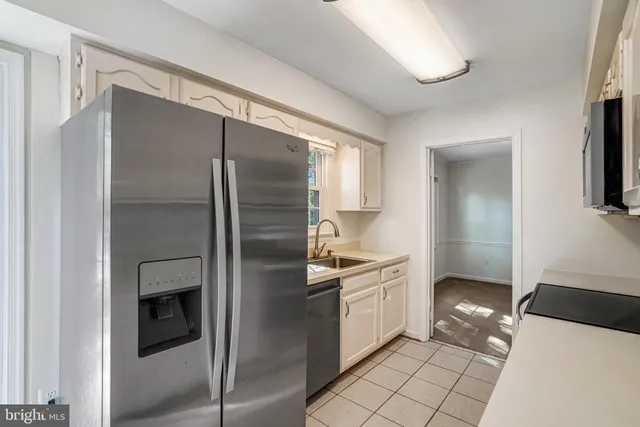 a large white kitchen with cabinets and stainless steel appliances
