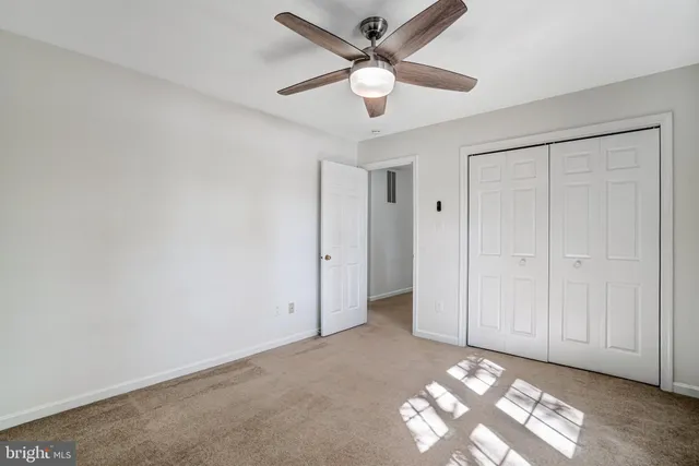 an empty room with a chandelier fan