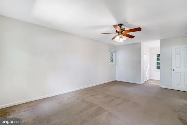 a view of an empty room with a ceiling fan