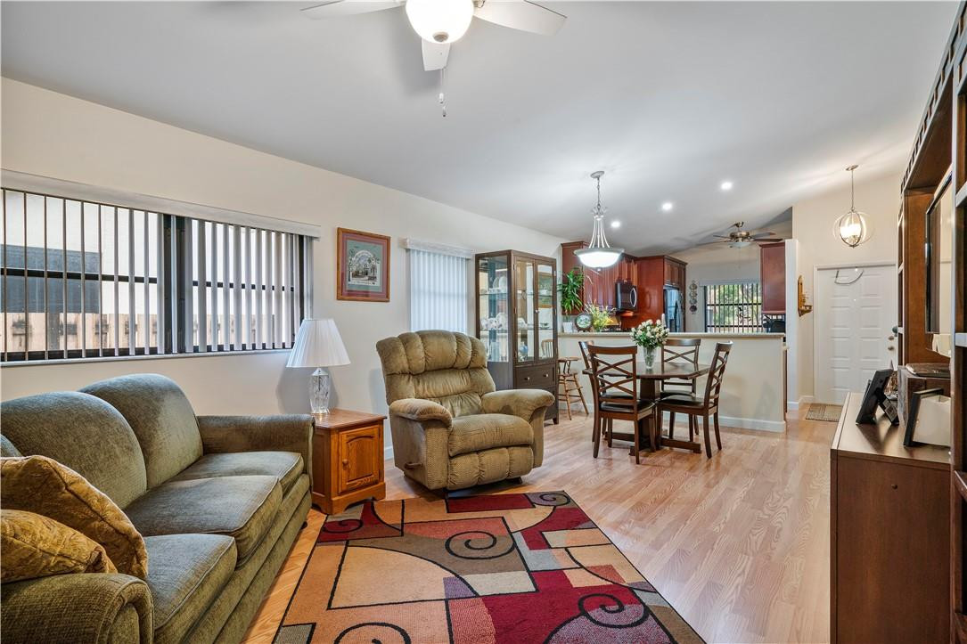 8046 Summerview Terrace Boca Raton, FL 33496 - Photo 12 of 25 a living room with furniture and a dining table with wooden floor