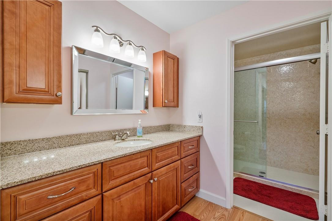 8046 Summerview Terrace Boca Raton, FL 33496 - Photo 19 of 25 a bathroom with a granite countertop sink a mirror and a shower