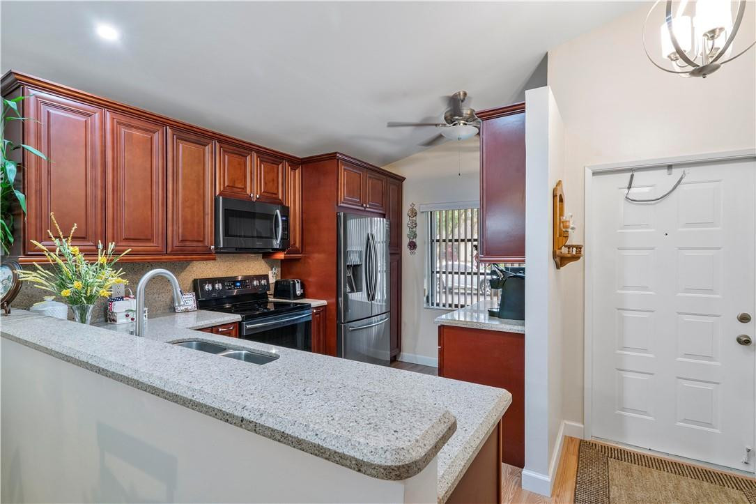 8046 Summerview Terrace Boca Raton, FL 33496 - Photo 5 of 25 a kitchen with stainless steel appliances granite countertop a refrigerator a stove top oven a sink and dishwasher