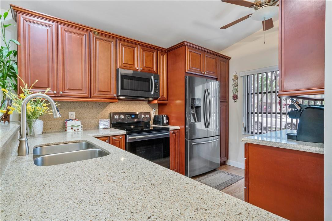 8046 Summerview Terrace Boca Raton, FL 33496 - Photo 10 of 25 a kitchen with stainless steel appliances granite countertop a refrigerator stove top oven and sink