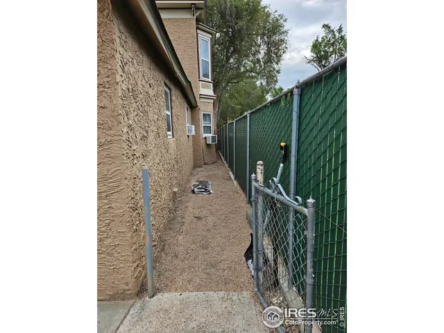 a backyard of a house with lots of green space and wooden fence