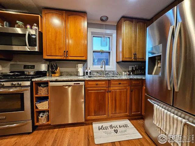 a kitchen with stainless steel appliances granite countertop a refrigerator a stove and a sink