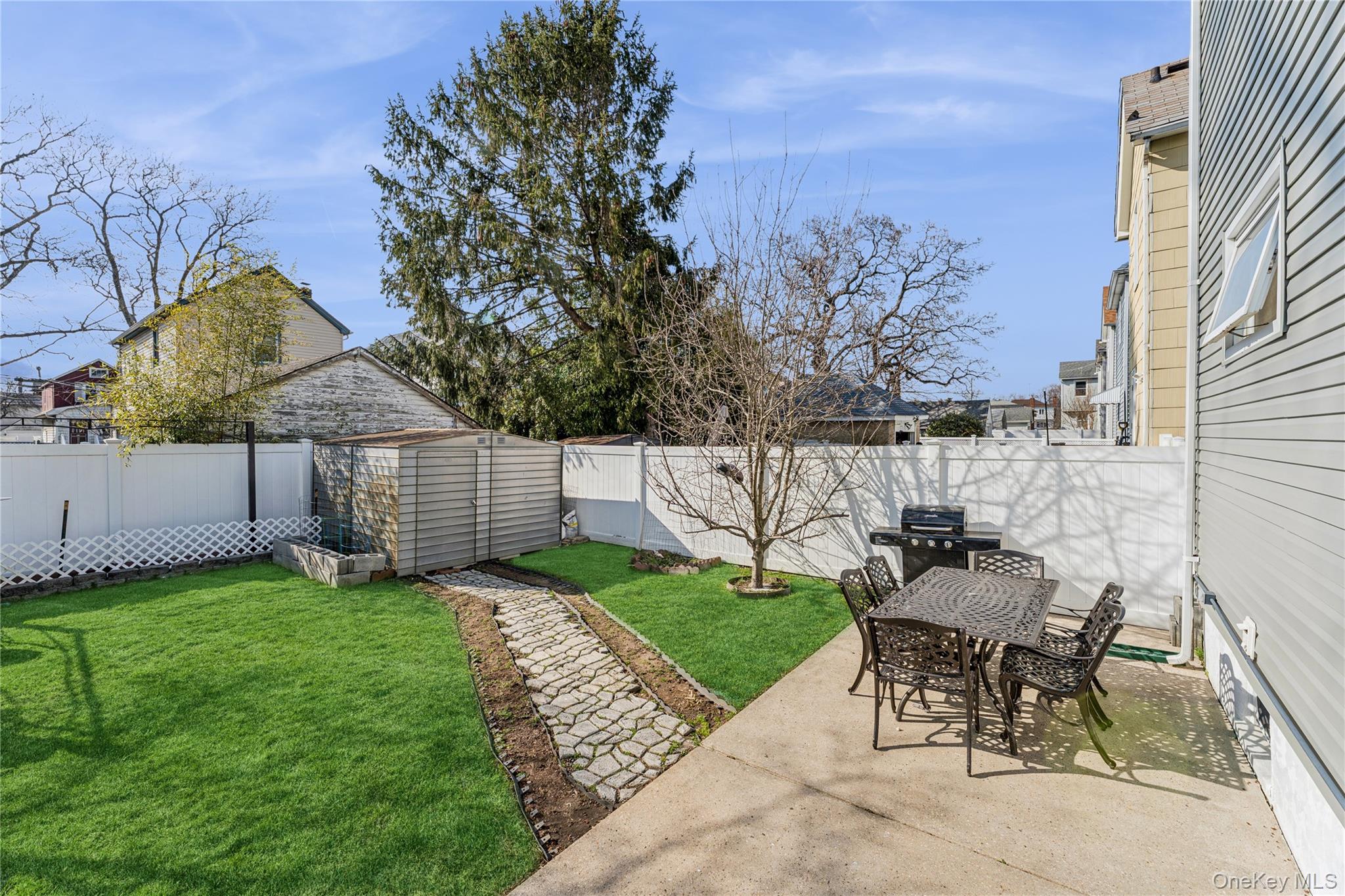 68 Putnam Avenue Valley Stream, NY 11580 - Photo 18 of 23 a view of a backyard with table and chairs and a fire pit