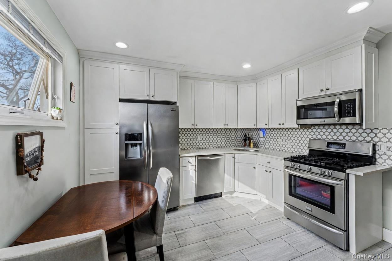 68 Putnam Avenue Valley Stream, NY 11580 - Photo 7 of 23 a kitchen with stainless steel appliances granite countertop a stove a sink dishwasher a refrigerator and a microwave