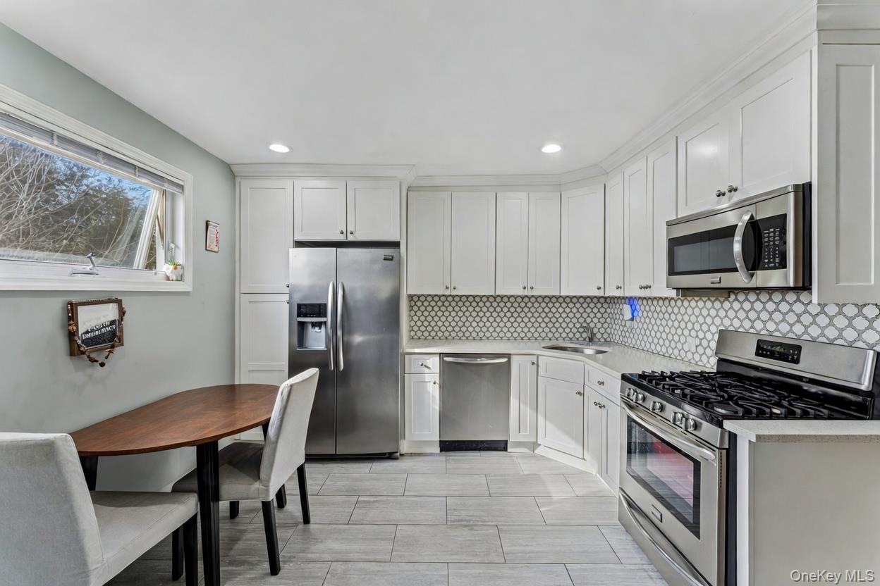 68 Putnam Avenue Valley Stream, NY 11580 - Photo 8 of 23 a kitchen with a stove a sink and a refrigerator