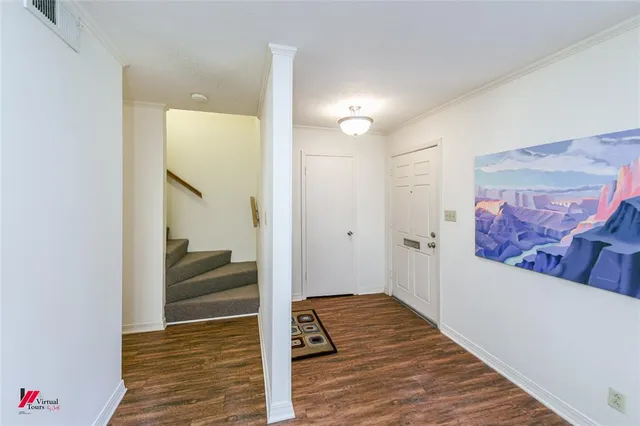 a view of a hallway with wooden floor and cabinet