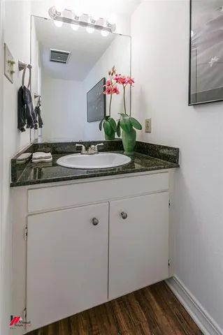 a bathroom with a granite countertop sink and a mirror