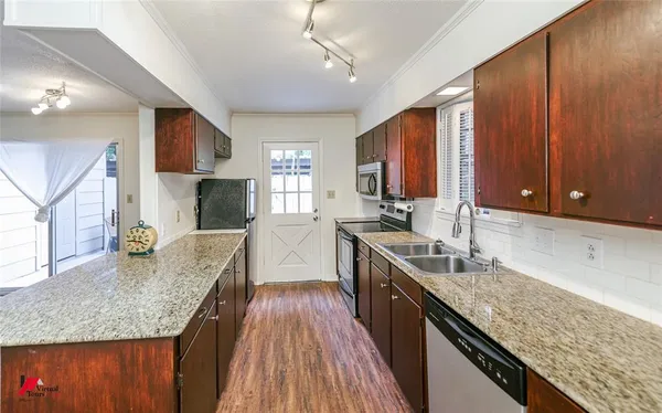 a kitchen with stainless steel appliances granite countertop a sink stove and refrigerator