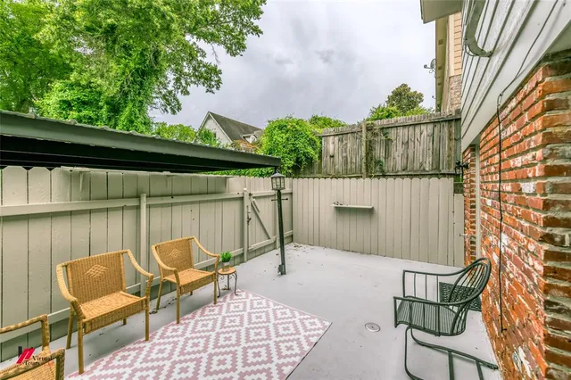 a view of a house with a small yard and a large tree