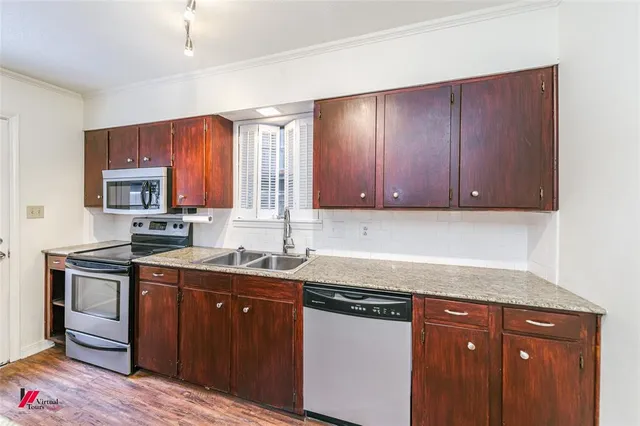 a kitchen with stainless steel appliances granite countertop a sink stove and microwave