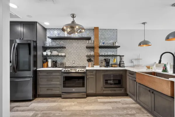 a kitchen with stainless steel appliances granite countertop a sink stove and refrigerator
