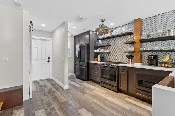 a kitchen with stainless steel appliances kitchen island granite countertop a refrigerator and a sink