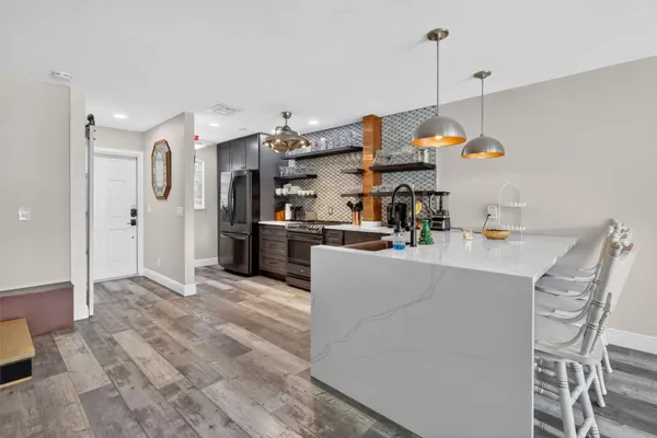 a kitchen with stainless steel appliances granite countertop a sink and a refrigerator