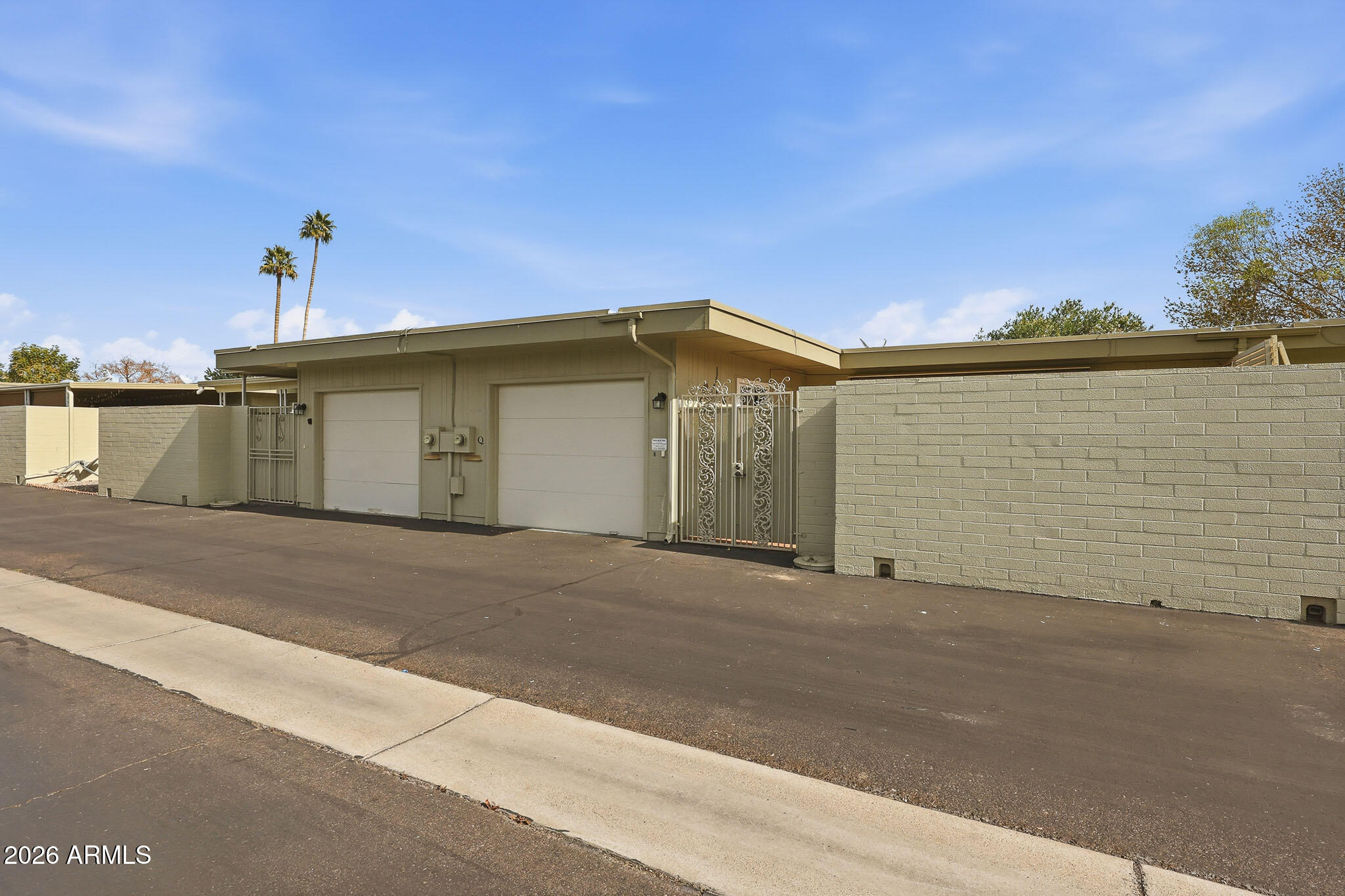 9970 West Royal Oak Road, Unit Q Sun City, AZ 85351 - Photo 35 of 38 a front view of a house with a yard and garage
