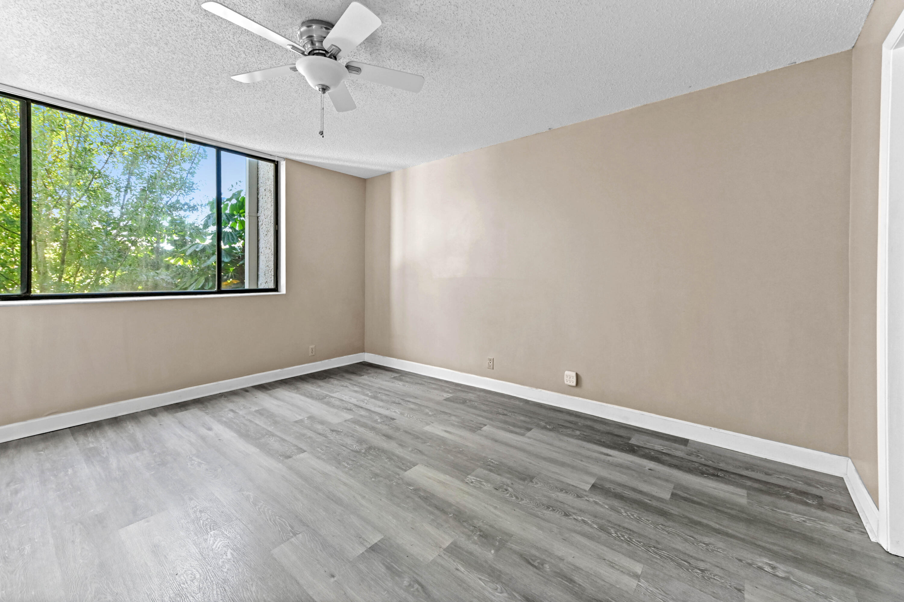 4080 Tivoli Court, Unit 202 Lake Worth, FL 33467 - Photo 14 of 28 wooden floor in an empty room with a window