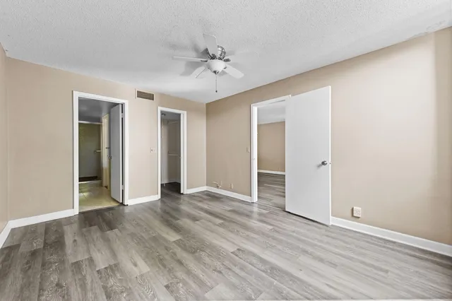a view of an empty room with wooden floor