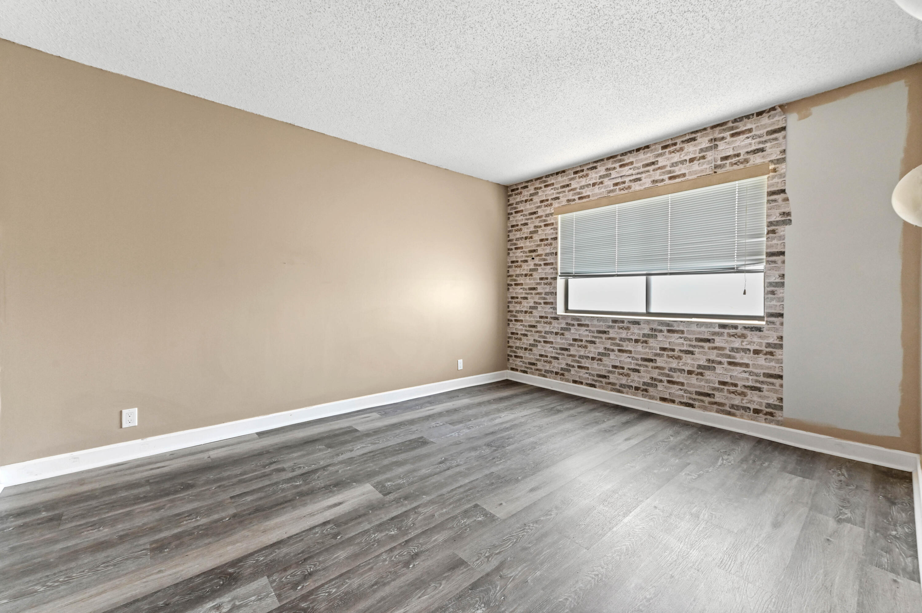 4080 Tivoli Court, Unit 202 Lake Worth, FL 33467 - Photo 19 of 28 a view of an empty room with wooden floor and a window